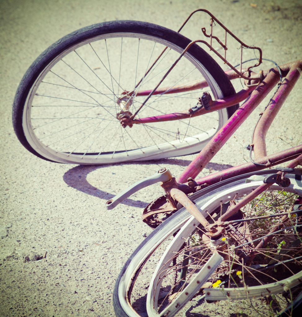 broken bike abandoned on the edge of the road. Processed for vintage tone effect.